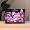 Na zdjęciu znajduje się pudełko puzzli z grafiką przedstawiającą postacie i elementy z motywem Disney Lorcana, otoczone fioletowymi i różowymi odcieniami. Na pudełku widnieje napis "Disney Lorcana", "1000 Ravensburger Puzzle" oraz logo "Ravensburger".