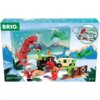 Na zdjęciu znajduje się opakowanie kalendarza adwentowego BRIO Dino 63612000, przedstawiające kolorowe figurki dinozaurów, pociąg, samochód i inne akcesoria na tle górskiego krajobrazu. Widoczne są również napisy: "BRIO" oraz "Advent Calendar 36120", a w prawym dolnym rogu oznaczenie wiekowe "3+".