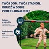Na zdjęciu widoczna jest bramka do piłki nożnej z napisem "HUDORA" na górnej belce, a obok niej znajduje się dziecko w beżowym stroju sportowym i rękawicach. Na tle zdjęcia umieszczono tekst: "TWÓJ DOM, TWÓJ STADION. OBUDŹ W SOBIE PROFESJONALISTĘ!", a pon