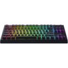 Czarna klawiatura mechaniczna z podświetleniem RGB, na której widoczne są klawisze z literami, cyframi i symbolami. Na dolnej krawędzi obudowy znajduje się logo "RAZER".