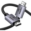 Na zdjęciu widoczny jest czarny kabel HDMI z plecionym oplotem, zakończony dwoma metalicznymi wtykami, na których znajduje się napis "HDMI 8K".