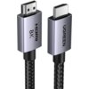 Na zdjęciu widoczny jest czarny kabel HDMI z plecionym oplotem, zakończony dwoma metalicznymi wtykami. Na jednym wtyku znajduje się napis "HDMI 8K", a na drugim "UGREEN".