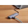 Na zdjęciu znajduje się hub USB typu C marki UGREEN, podłączony do laptopa, z widocznymi portami i podłączonym niebieskim kablem. Na powierzchni huba widoczny jest napis "UGREEN".