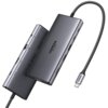 Na zdjęciu widoczny jest hub USB typu C w kolorze szarym z kilkoma portami, na którym znajduje się napis "UGREEN 4K 60Hz". Kabel z końcówką USB typu C jest przymocowany do urządzenia, a na jego końcówce również widnieje napis "UGREEN".