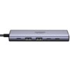 Na zdjęciu widoczny jest hub USB w kolorze srebrnym z sześcioma portami, w tym USB Typu C i USB Typu A. Na powierzchni urządzenia znajduje się napis "UGREEN 4K 60Hz".
