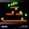 Na zdjęciu widoczna jest pikselowa grafika z gry "Bubble Bobble" z 1986 roku, przedstawiająca zielonego smoka na tle platform i unoszących się baniek. W lewym dolnym rogu znajduje się napis "TAITO", a w prawym dolnym rogu tekst "BUBBLE BOBBLE 1986 / ACTIO