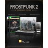 Okładka gry "Frostpunk 2 - Icebreaker Edition" na Xbox Series X jest widoczna obok dioramy przedstawiającej miasto. Na zdjęciu znajdują się również artbook i kod do pobrania noweli, a w tle widnieje napis "FROSTPUNK 2 ICEBREAKER EDITION".