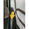 Na zdjęciu widoczny jest fragment metalowej konstrukcji w kolorze antracytowym z przyczepioną żółtą strzałką skierowaną w dół. W tle znajduje się szara, teksturowana ściana.