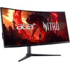 Monitor o zakrzywionym ekranie wyświetla grafikę z czerwonym smokiem i postacią na tle krajobrazu, z widocznymi napisami "acer" i "NITRO". Monitor jest zamontowany na czarnym stojaku.