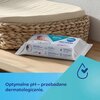 Na zdjęciu znajduje się opakowanie chusteczek nawilżanych z napisem "99% woda" oraz logo "canpol babies", leżące na drewnianej powierzchni obok plecionego kosza. Na dole zdjęcia widnieje niebieski pasek z tekstem: "Optymalne pH – przebadane dermatologiczn