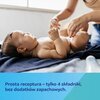 Na zdjęciu widać niemowlę leżące na ciemnym kocu, a obok niego osobę dorosłą, która się nim zajmuje. Na dole zdjęcia znajduje się tekst: "Prosta receptura – tylko 4 składniki, bez dodatków zapachowych."