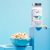 Białe opakowanie suplementu diety BESTLAB VitaMinBest z widocznym napisem "VITAMIN BEST" stoi na niebieskim postumencie, obok miseczki wypełnionej kapsułkami. Na etykiecie znajdują się informacje o kompleksie witamin i minerałów oraz 22 antyoksydantach.
