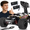 Na zdjęciu znajduje się zdalnie sterowany samochód z dużymi oponami i napisem "XTREME" na boku, obok którego widoczne są dwa akumulatory z napisem "Xblitz BLAZE", pilot z napisem "Xblitz" oraz kabel USB. W tle znajduje się osoba pokazująca gest kciuka w g