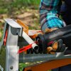 Na zdjęciu widoczna jest piła szablasta z napisem "BRUSHLESS MOTOR", przecinająca biały plastikowy rurkę, trzymana przez osobę w rękawicach roboczych. W tle znajduje się fragment metalowej konstrukcji z widocznym logo "WORX".