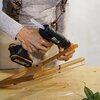 Osoba używa pistoletu do kleju WORX WX045.9, trzymając drewniane elementy na stole roboczym. Na urządzeniu widoczny jest napis "20V Power Share".