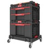 Czarny zestaw skrzynek narzędziowych z czerwonymi uchwytami, umieszczony na platformie z kółkami. Na skrzynkach widoczne jest logo "QBRICK System".