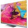 Telewizor z dużym ekranem wyświetla abstrakcyjną grafikę w intensywnych kolorach, takich jak różowy, fioletowy, niebieski i złoty. Na dolnej ramce widoczne jest logo "HAIER".