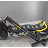 Czarno-żółta hulajnoga elektryczna z widocznym napisem "SCRAMBLER DUCATI" na boku oraz "CROSS-E SPORT" na kierownicy, stoi na szarym tle. Hulajnoga ma szeroki podest z wzorem w szaro-czarne piksele i żółte akcenty.