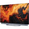 Telewizor z wyświetlaczem OLED prezentuje abstrakcyjny wzór w odcieniach pomarańczu, czerwieni i czerni. Na dolnej ramce widoczne jest logo "Haier".
