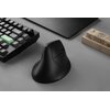 Na zdjęciu znajduje się czarna mysz Keychron M5-A23 o ergonomicznym kształcie, obok klawiatury z zielonym klawiszem i drewnianego kalendarza z datami. Tło stanowi szara powierzchnia biurka.