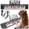 Na zdjęciu znajduje się czarny keyboard z podświetlanymi klawiszami, stojak na nuty oraz mikrofon z przewodem i zasilacz. Na keyboardzie widoczny jest napis: "61 KEYS Electronic Keyboard MQ 6151L Czarny".