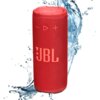 Czerwony głośnik mobilny z widocznym logo "JBL" na tle rozpryskującej się wody. Na górze głośnika znajdują się przyciski sterujące: minus, play, plus.