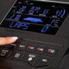 Na zdjęciu widoczny jest panel sterowania z wyświetlaczem pokazującym dane takie jak "WATT 20", "TIME 0:27", "SPEED 6.5", "RPM 47", "CALORIES DISTANCE 2.00", "LAPS 0", oraz przyciski z napisami "INTERVAL", "WATT", "HR1", "HR2", "HR3", "ENTER", "+", "RESET