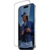 Szkło hartowane PANZERGLASS Ultra-Wide Fit FastFit jest nałożone na ekran smartfona, na którym widoczna jest osoba w niebieskiej kurtce i czapce z daszkiem. Produkt jest przeznaczony do Apple iPhone 17/16 Pro.