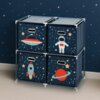 Granatowy regał z czterema szufladami ozdobionymi motywami kosmicznymi, takimi jak statek kosmiczny, astronauta, rakieta i planeta z pierścieniami, stoi na tle ściany z wzorem gwiazd. Szuflady mają metalowe uchwyty i są umieszczone w przezroczystej ramie.