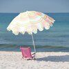 Na zdjęciu widoczny jest wielokolorowy parasol plażowy z falistym wzorem w odcieniach zieleni, pomarańczu i różu, stojący na piaszczystej plaży obok różowego leżaka. W tle rozciąga się spokojne morze pod błękitnym niebem.