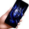 Na zdjęciu widać dłoń trzymającą smartfon z wyświetlaczem, na którym znajduje się niebieski wzór z symbolem tarczy i okiem. Tło ekranu ma efekt falowania, co sugeruje zastosowanie szkła prywatyzującego.