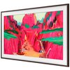Ramka telewizora Samsung The Frame 75 cali w kolorze ciemnego drewna prezentuje obraz z kolorowymi, abstrakcyjnymi formami przypominającymi krajobraz z dominującymi odcieniami różu, zieleni i pomarańczu. Obraz jest otoczony białą ramką, która podkreśla je