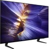 Telewizor z cienką ramką wyświetla kolorowy obraz przypominający abstrakcyjną kompozycję z dominującymi odcieniami fioletu i żółci. Urządzenie stoi na dwóch czarnych nóżkach.