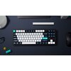Na zdjęciu znajduje się klawiatura mechaniczna w kolorach czarno-biało-niebieskim z klawiszami oznaczonymi m.in. jako "tab", "caps lock", "shift", "enter", "backspace", "option", "control", "home", "end", "page up", "page down", "del", "ins", oraz klawisz