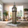 Na zdjęciu znajduje się model 3D przedstawiający wieżę Big Ben, zbudowany z puzzli, umieszczony na drewnianym stole w jasnym, przytulnym wnętrzu z roślinami i sofą w tle. Na podstawie modelu widoczny jest napis "BIG BEN".