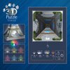 Na zdjęciu znajduje się opakowanie puzzli 3D "RAVENSBURGER Iconics Wieża Eiffla 12008024 (243 elementy)" z widocznymi elementami wieży oraz opcjami podświetlenia LED w różnych kolorach. Na opakowaniu widnieje napis "3D Puzzle Iconics" oraz schemat zmiany 