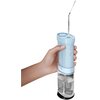 Na zdjęciu widoczny jest niebieski, bezprzewodowy irygator PHILIPS Sonicare Compact Flosser 1000 HX3333/24 trzymany w dłoni. Urządzenie ma przezroczysty zbiornik na wodę i kilka przycisków na obudowie.