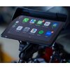 Na zdjęciu widoczny jest tablet zamontowany na uchwycie, z wyświetlonymi ikonami aplikacji: Phone, Maps, Messages, Now Playing, Car, Calendar, Settings, Google Maps, Spotify i Zoom. Ekran pokazuje powiadomienia przy Messages (9) i Zoom (6).