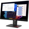 Na zdjęciu widoczny jest monitor z kilkoma otwartymi oknami aplikacji, w tym wiadomości tekstowe, e-maile oraz panel z danymi finansowymi. Na podstawie monitora znajduje się logo "Lenovo".