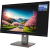 Monitor z wyświetlaczem prezentującym krajobraz z kwitnącymi drzewami i górami w tle, na podstawce z logo "Lenovo". W prawym górnym rogu ekranu widoczna jest miniatura z panelami słonecznymi oraz napis "Next slide".