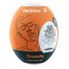 Owalny przedmiot w pomarańczowym kolorze z białym napisem "Satisfyer" oraz stylizowaną grafiką twarzy. Na dole widnieje napis "Crunchy Masturbator Egg", a po prawej stronie znajduje się ilustracja przedstawiająca strukturę wewnętrzną produktu.