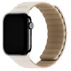 Jasnobeżowo-beżowy pasek silikonowy do zegarka Apple Watch z widocznym logo "Holdit" na górnej części paska. Zegarek ma czarny ekran i metalową kopertę z widocznym przyciskiem bocznym.