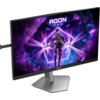 Monitor AOC Agon Pro AG246FK6 z wyświetlaczem pokazującym postać w futurystycznym stroju na tle kosmicznej scenerii z fioletowymi i niebieskimi elementami. Na ekranie widoczny jest napis "AGON PRO".