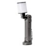 Szara lampa warsztatowa z białym, cylindrycznym kloszem na ruchomym przegubie, posiada ergonomiczny uchwyt z teksturowaną powierzchnią. Produkt ma prosty, funkcjonalny design z kilkoma otworami i zaczepem na uchwycie.