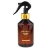 Brązowa butelka z czarnym atomizerem i złotym pierścieniem, na której widnieje napis: "SORVELLA Home Spray Premium Sandalwood".