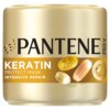 Pojemnik w złotym kolorze z napisem "PANTENE PRO-V" oraz "KERATIN PROTECT MASK INTENSIVE REPAIR". Na opakowaniu widoczne są również kapsułki z napisem "PRO-V" i okrągłe logo z tekstem "SWISS VITAMIN INSTITUTE TESTED".