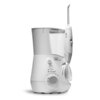 Biały irygator stacjonarny z napisem "waterpik waterflosser" na obudowie, posiada pokrętło z numeracją od 1 do 10 oraz przełączniki oznaczone jako "Floss" i "Massage". Obok znajduje się uchwyt z dyszą i przyciskiem "On/Off".