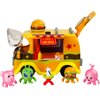 Zestaw figurek przedstawia kolorowy food truck z napisem "Pinata Yum Hatch" oraz cztery różnobarwne figurki postaci ustawione przed nim. Na dachu pojazdu znajduje się duży model hamburgera, a w okienku widoczne są miniaturowe akcesoria, takie jak frytki i