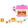 Zestaw figurek ZURU Little Live Pets Mama Surprise Minis zawiera różowe i beżowe plastikowe domki z przezroczystymi ścianami, wypełnione brązowymi wiórkami, oraz cztery figurki chomików w różnych kolorach i kształtach. Obok figurek znajduje się zielony pl