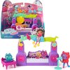 Zestaw figurek przedstawia kolorową scenę z instrumentami muzycznymi i postaciami z bajki, w tym mikrofonem i klawiaturą. Na opakowaniu widnieje napis: "Gabby's Dollhouse The Movie" oraz "Paw-some Party Story", a także ostrzeżenie: "WARNING: CHOKING HAZAR